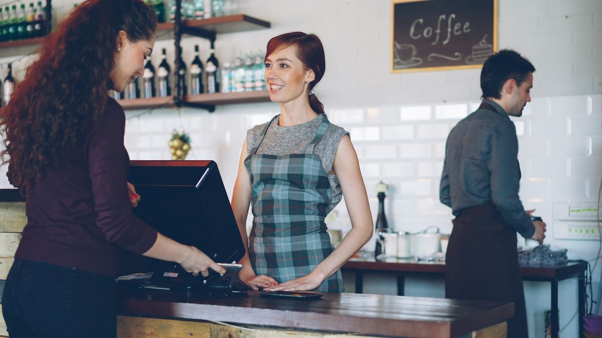 Kunde betaler ved disken i en kaffebar